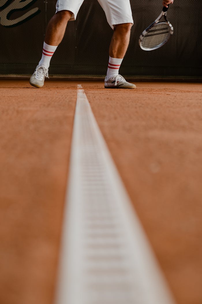 my-expertise Close-up of a tennis player on a clay court, focusing on the racket and footwork.